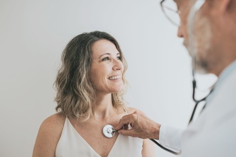 Doctor listening to patient's heart with stethoscope